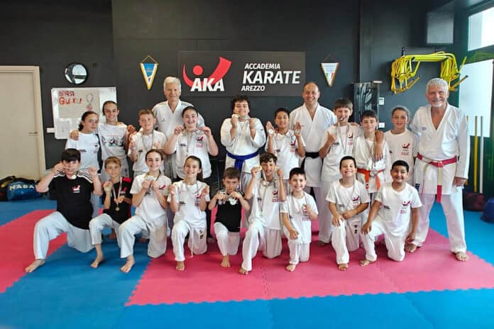 AREZZO – L’A.K.A. - Accademia Karate Arezzo vince la Coppa Toscana Giovanissimi. L’importante manifestazione giovanile di karate rivolta alle categorie da Under6 a Under12 ha visto trionfare la società aretina guidata dai Maestri Enzo Bertocci e Roberto Petrini che, con ventiquattro atleti e con un totale di ventisei medaglie, è risultata la migliore in assoluto della regione. La prova è stata organizzata dal Comitato Regionale Toscana - Settore Karate della FIJLKAM nella fiorentina Certaldo con oltre duecento bambini e bambine che si sono messi alla prova tra varie specialità quali Kumite - Combattimento, Kata - Forme, Percorso e Gioco Tecnico del Palloncino e, in questo contesto d’eccezione, l’A.K.A. è risultata assoluta protagonista con quattordici ori, tre argenti e nove bronzi. La soddisfazione di centrare un doppio oro in Kumite e Gioco Tecnico del Palloncino è stata vissuta da Vittoria Farini, Adele Galletti, Marvin Jasari, Gregorio Passalacqua e Niccolò Zei, poi a salire sul gradino più alto del podio sono stati anche Rayan Caneschi con l’oro nel Gioco del Palloncino e il bronzo nel Kumite, e Denise Formichella, Cristian Nicchi e Riccardo Zei che hanno tutti meritato l’oro nel Kumite e il bronzo nel Gioco Tecnico del Palloncino. La Coppa Toscana Giovanissimi ha visto festeggiare anche Massimo Bardazzi con l’argento nel Gioco Tecnico del Palloncino e il bronzo nel Kata, Davide Ercolani con l’argento nel Kumite e il bronzo nel Gioco Tecnico del Palloncino, Johan Geers con l’argento nel Kumite, Elver Jasari con l’argento nel Kumite, Francesco Rubechi con due bronzi nel Gioco Tecnico del Palloncino e nel Percorso, Tommaso Casamassima con il bronzo nel Gioco Tecnico del Palloncino, Dylan Bartoli con il bronzo nel Kumite e Filippo De Luca con il bronzo nel Kumite. Ai piazzamenti sul podio si aggiungono anche tre quinti posti, sei settimi posti e cinque undicesimi posti che hanno contribuito al punteggio finale con cui l’A.K.A. è risultata la prima società tra ventuno realtà presenti da tutta la regione. La compagine aretina alla Coppa Toscana Giovanissimi ha fatto affidamento anche sulla presenza di Andrea De Coro come ufficiale di gara che ha dimostrato serietà e competenza nell’arbitraggio, inoltre la partecipazione alla manifestazione è stata sostenuta dagli sponsor ArezzoRecupera di Alessandro Nicchi, DLP Termoidraulica di Marco e Rossano Dini, Clean Tech Studio di Cesare Moretti e Panificio Fratelli Pierozzi. «La gara ha impegnato i nostri atleti dalla prima mattina al tardo pomeriggio - commenta il Maestro Bertocci, - in una vera e propria maratona di combattimenti ed esercizi dove abbiamo dimostrato preparazione e carattere, ma anche serenità e passione. Un ringraziamento particolare va alle famiglie che hanno accompagnato i figli alla manifestazione e che hanno condiviso e festeggiato i successi di tutti. Questi risultati sono motivo d’orgoglio e stimolo nel continuare il percorso di crescita dei nostri giovani atleti per formarli come sportivi ma anche come persone capaci di affrontare le sfide con impegno, rispetto e determinazione».