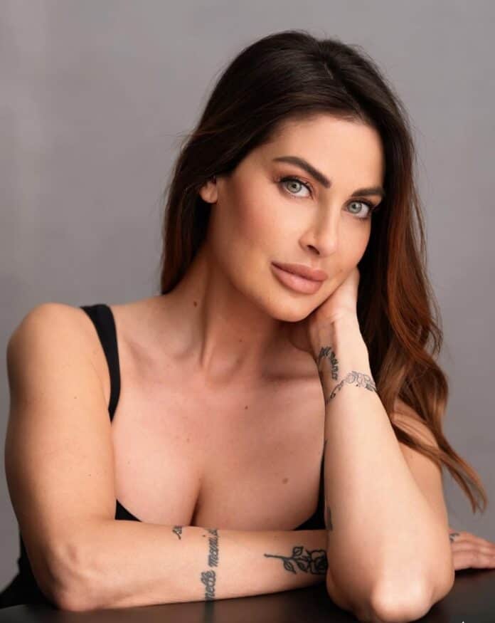 Bellissima donna con capelli castani e occhi azzurri, ritratto in primo piano, look naturale e tatuaggi visibili sulle braccia, foto di moda ed estetica.